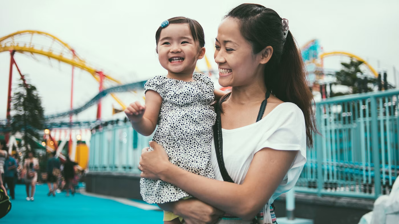 Mother and young child enjoying an amusement park